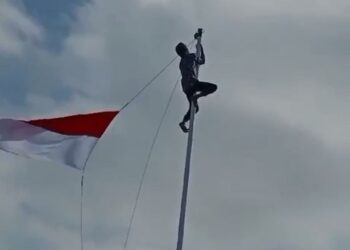 Heroik! Seorang Pria di Cidaun Nekat Naik Tiang Demi Kibarkan Bendera Yang Menyangkut