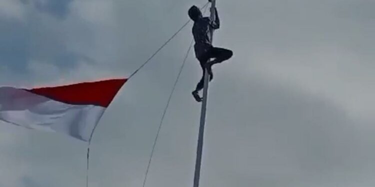 Heroik! Seorang Pria di Cidaun Nekat Naik Tiang Demi Kibarkan Bendera Yang Menyangkut